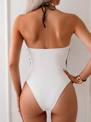 Back view of black and white one-piece with halter and cutout